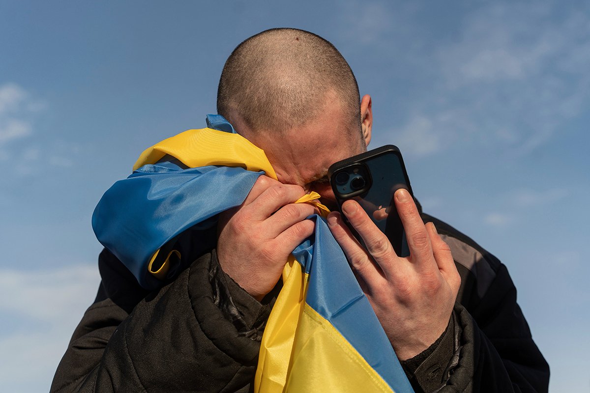 Недавно обмененный украинский военнопленный плачет, звоня своим родственникам после обмена пленными. Фото: Danylo Pavlov / AP Photo / Scanpix