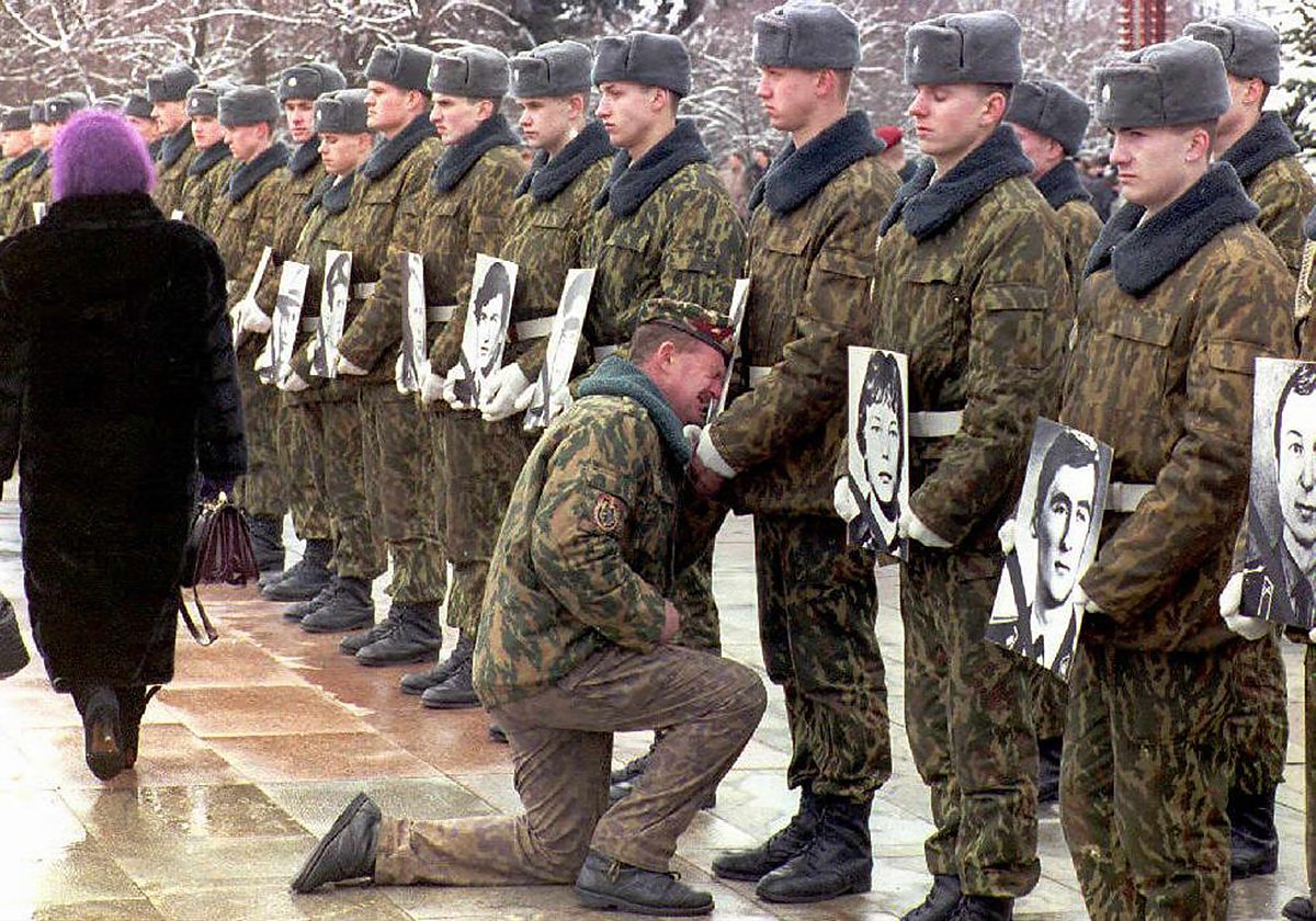 Ветеран афганской войны плачет перед фотографией своего товарища, погибшего в ходе конфликта, 1998 год. Фото: Виктор Драчев / EPA