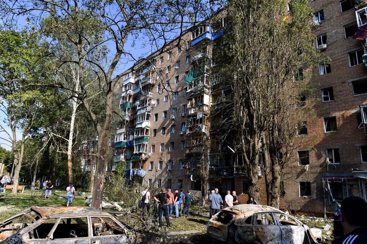 Люди собираются у жилого дома, поврежденного в результате обстрела в Курске, 11 августа 2024 года. Фото: AP Photo / Scanpix / LETA