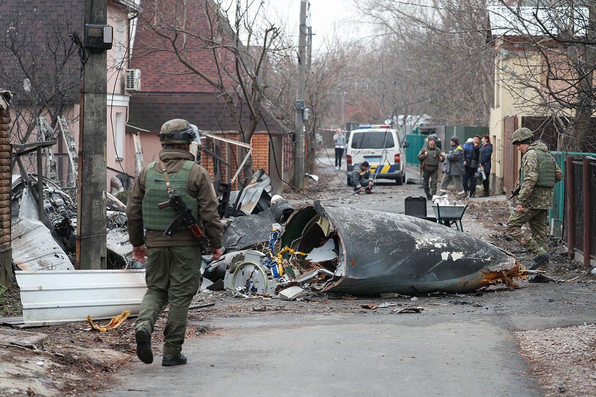 Солдаты рассматривают обломки военного самолета, сбитого ночью в Киеве, Украина, 25 февраля 2022 года. Фото: Сергей Долженко / EPA-EFE