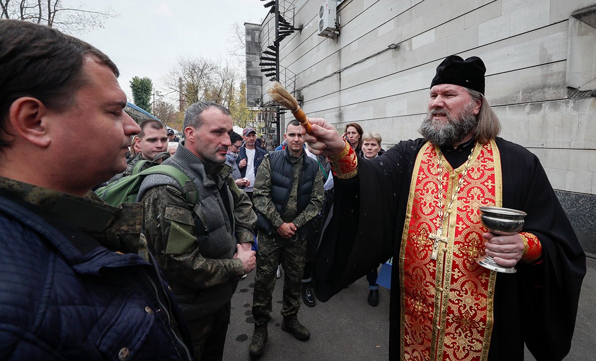 Православный священник благословляет российских солдат-срочников перед призывным пунктом во время военной мобилизации в России в Москве, Россия, 12 октября 2022 года. Фото: Юрий Кочетков / EPA-EFE